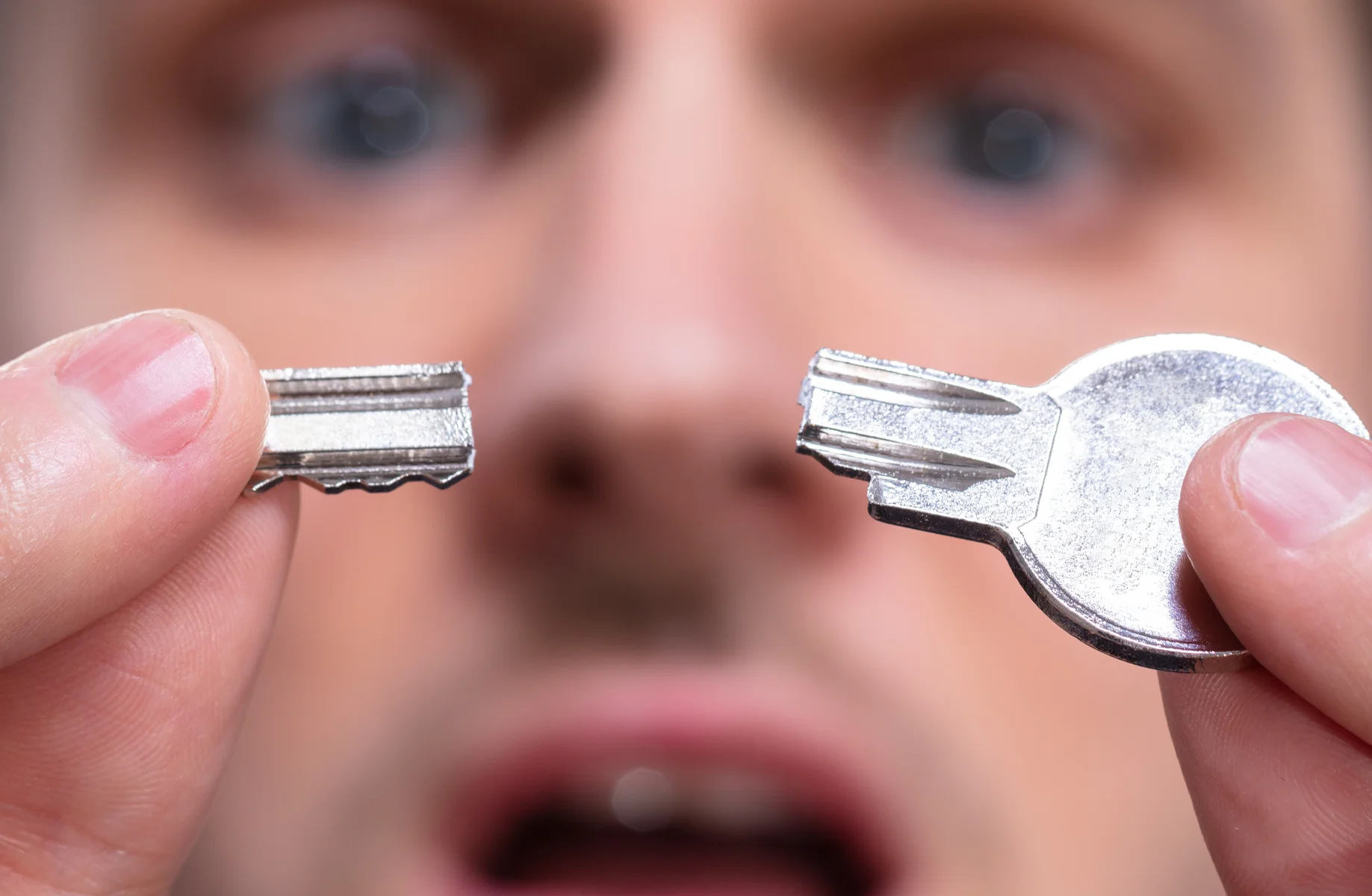 Close-up of a broken house key held in two pieces